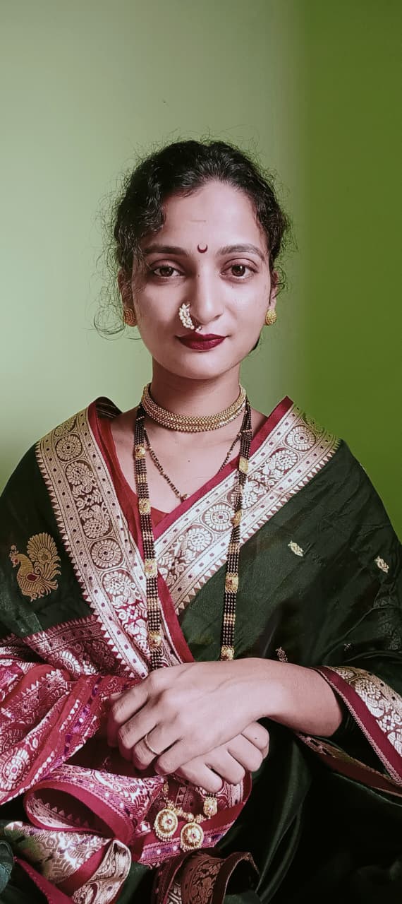 Woman in a green Paithani saree with gold zari border and traditional jewellery